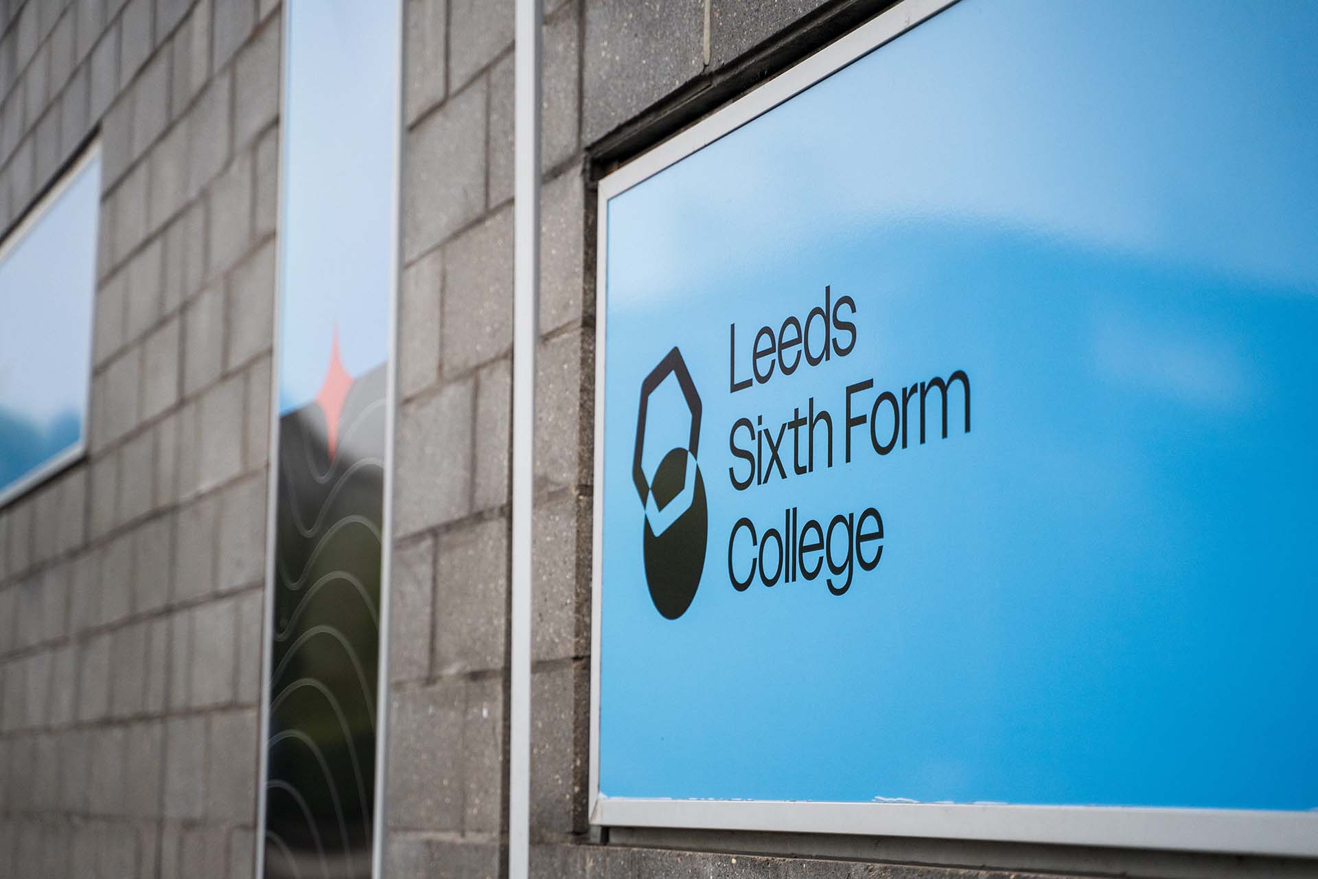 Poster on the outside of the Sixth Form College building with the Leeds Sixth Form Logo