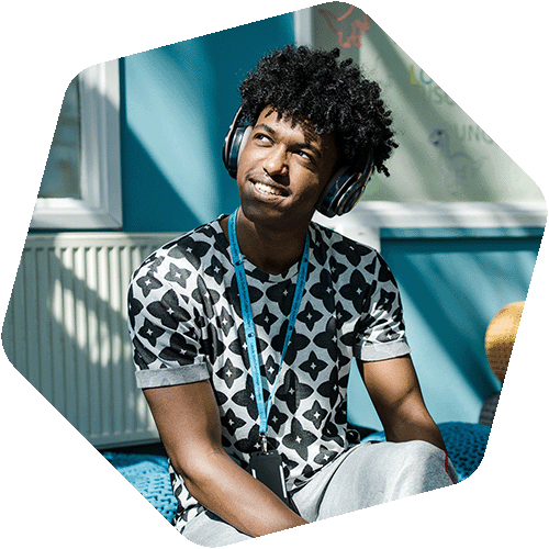 Leeds sixth form college student sat on a bean bag wearing headphones
